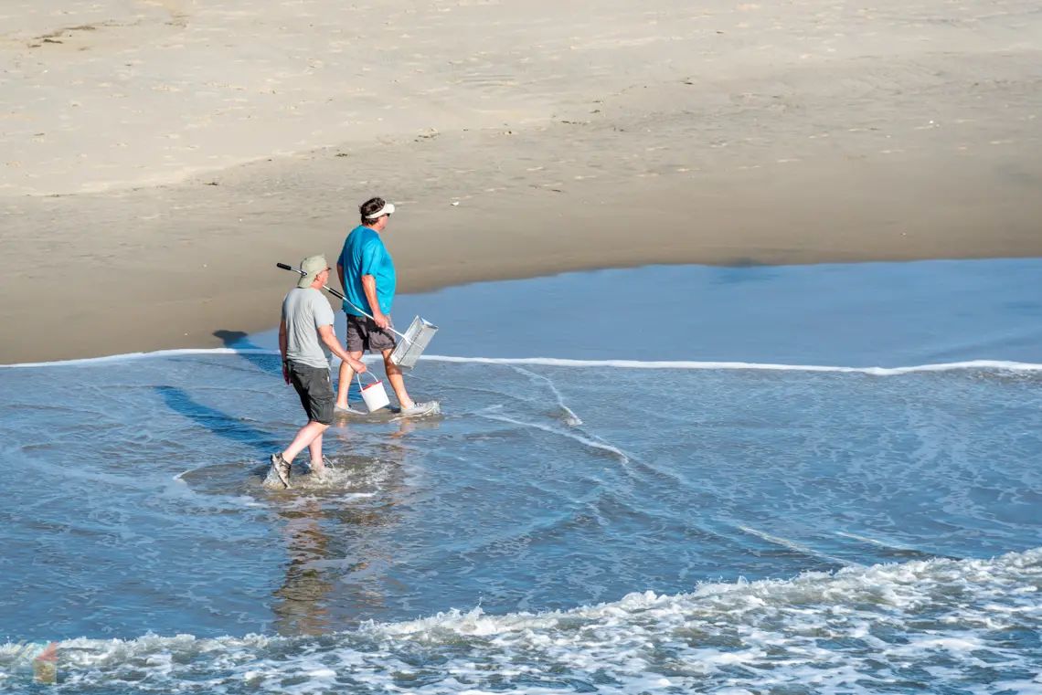 Two people walk on Nags Head beach